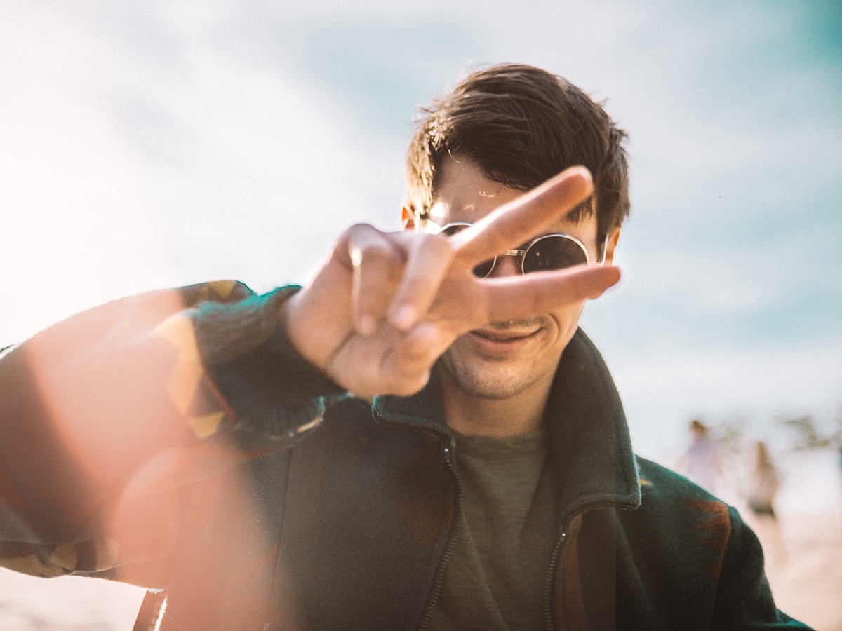 man in sunglasses raises two fingers up