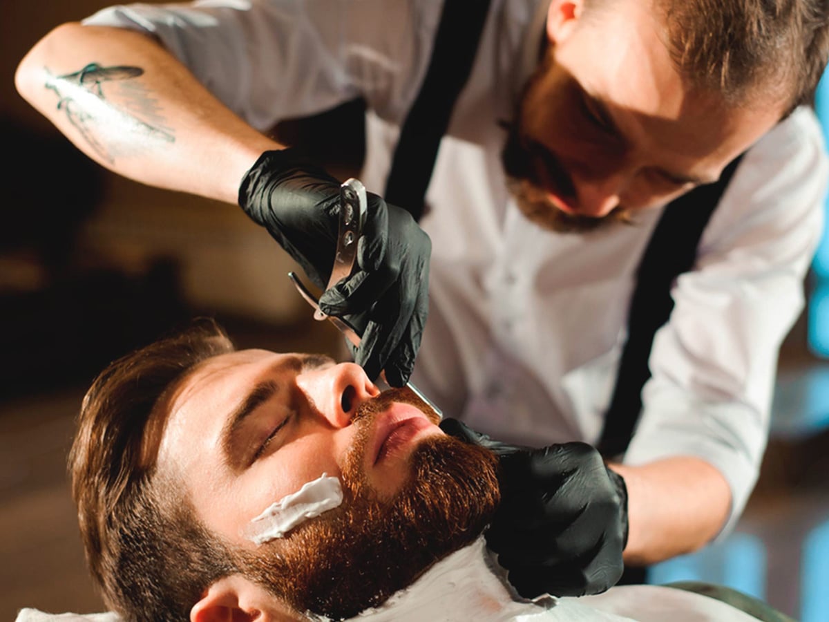 Stylish Barber Grooming a Man`s Beard