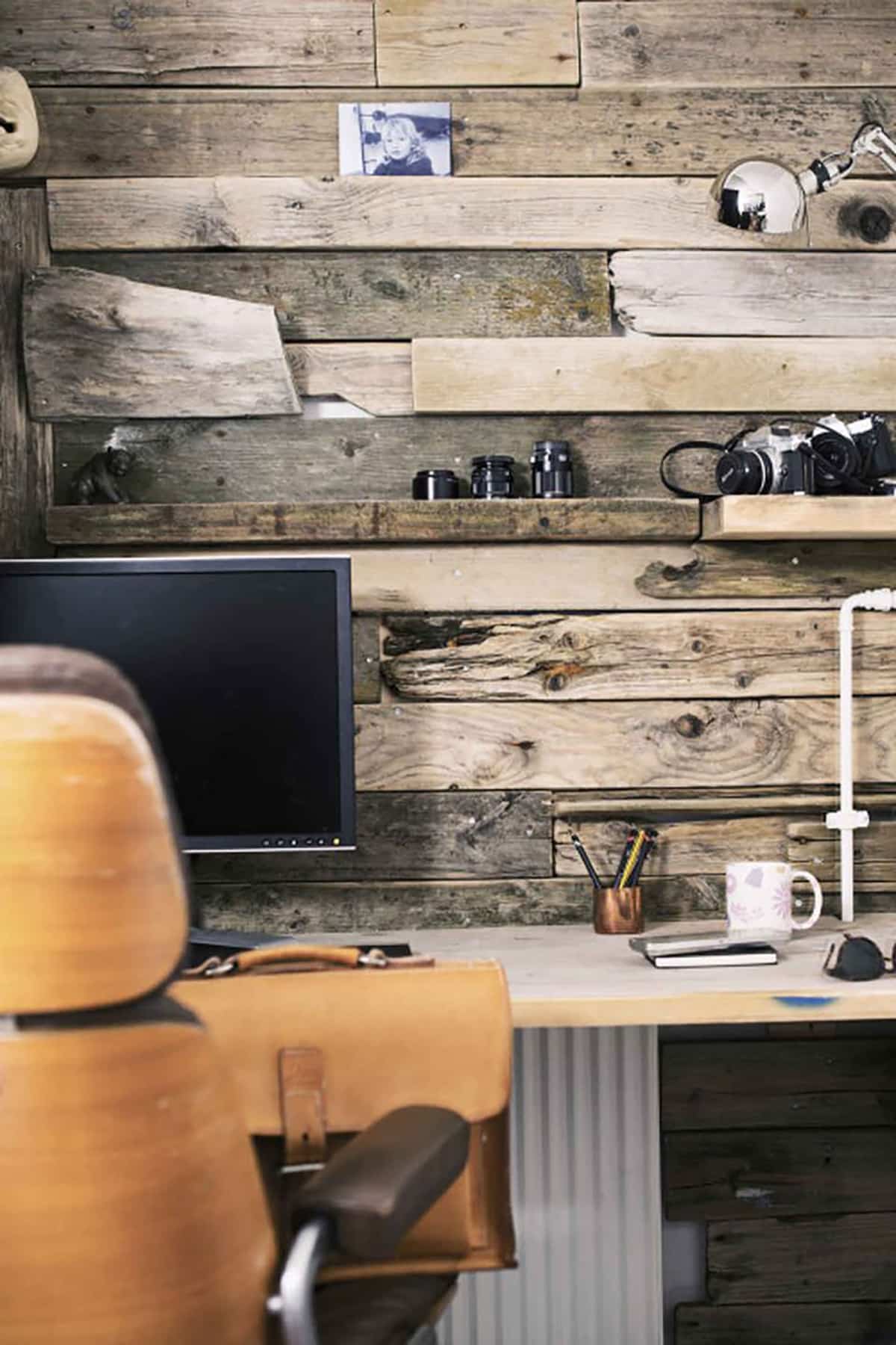 Wall with uneven sized wood planks behind an office table