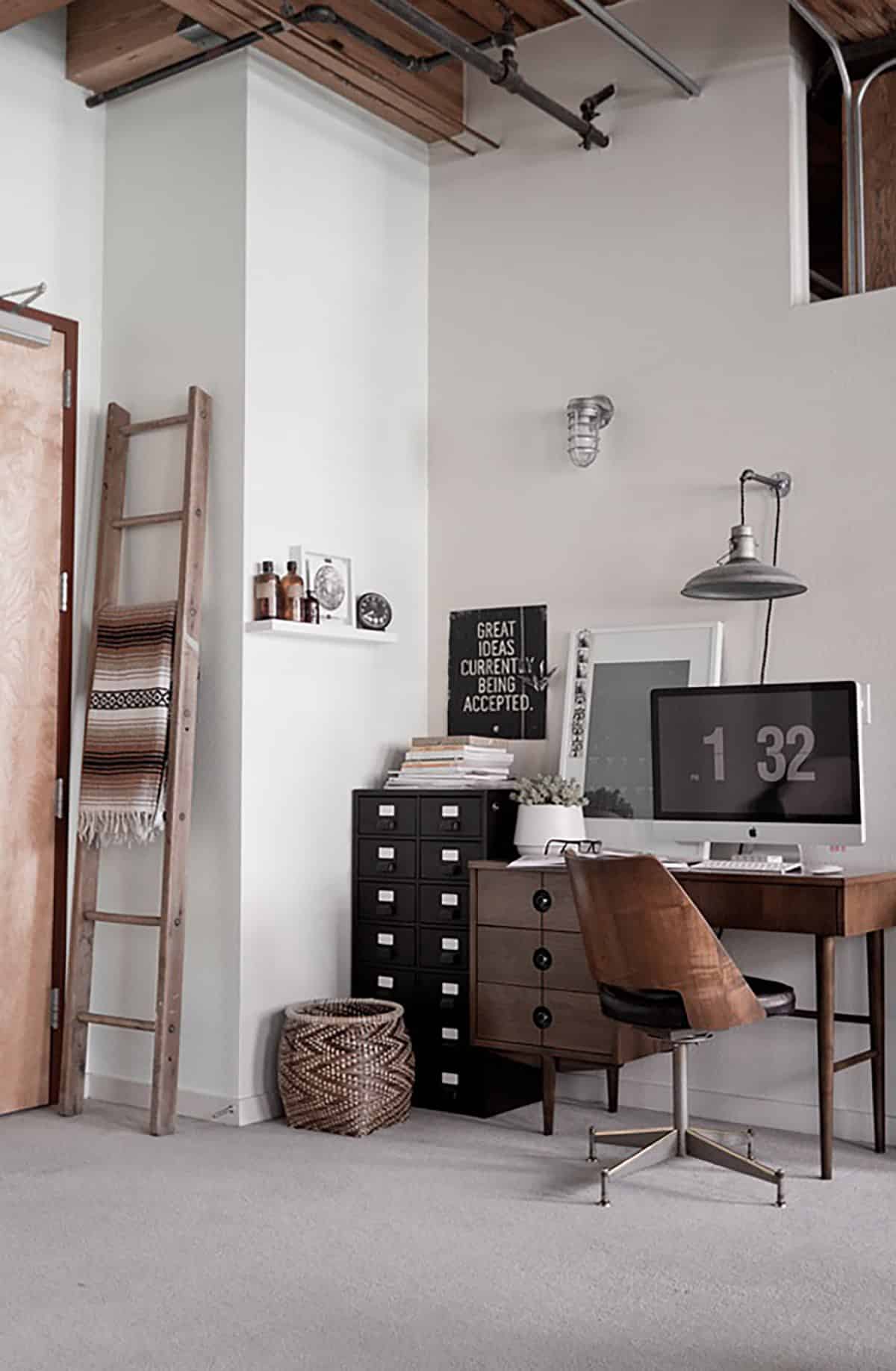 White walled room with work table and cabinets near corner and a ladder leaning on a wall near door