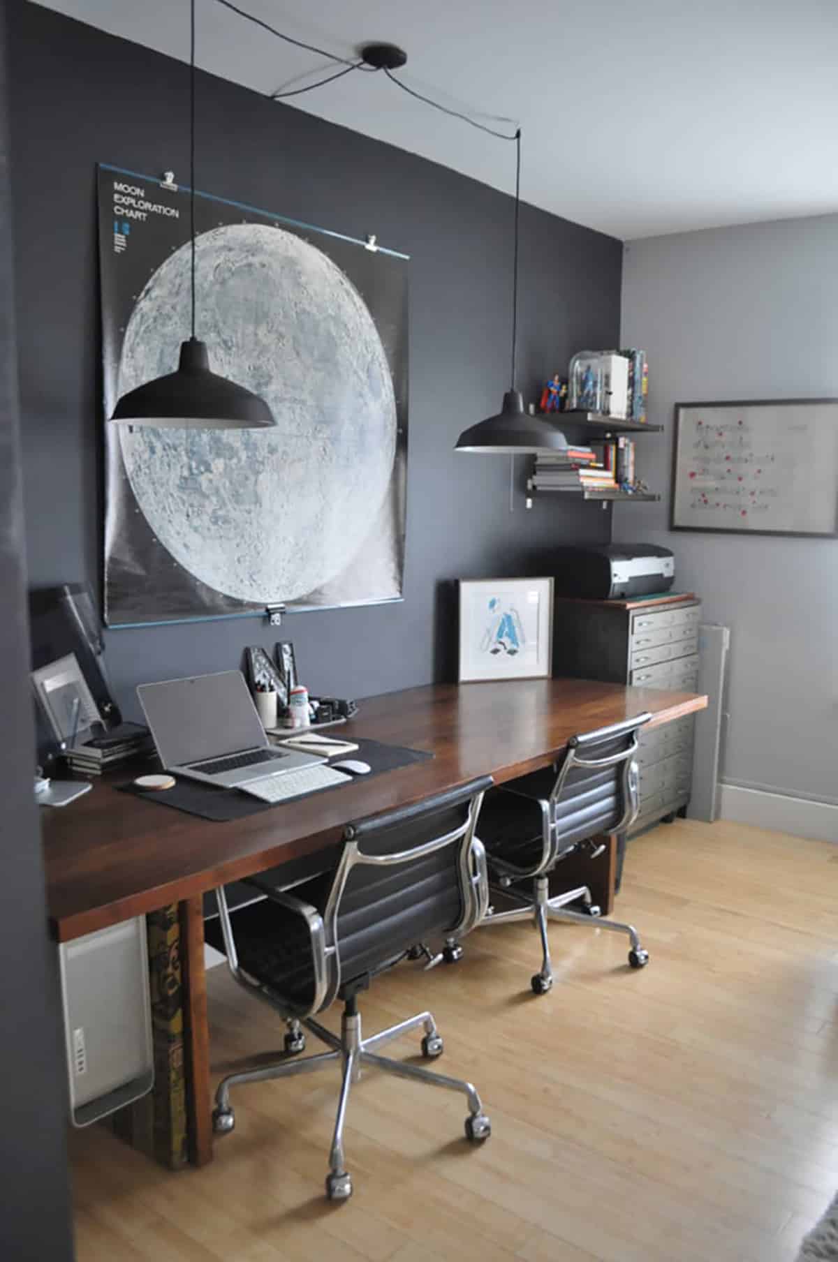 Home office with a large moon poster on wall behind table