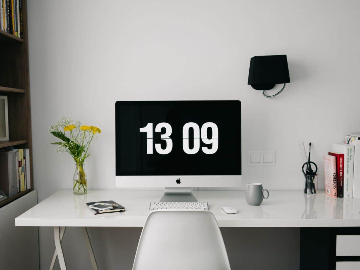 Desk with monitor showing time 13:09