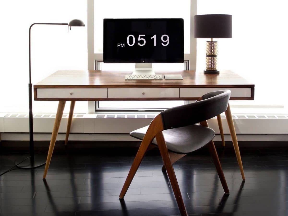 Wood office desk with slant legs and a wood chair in front of it