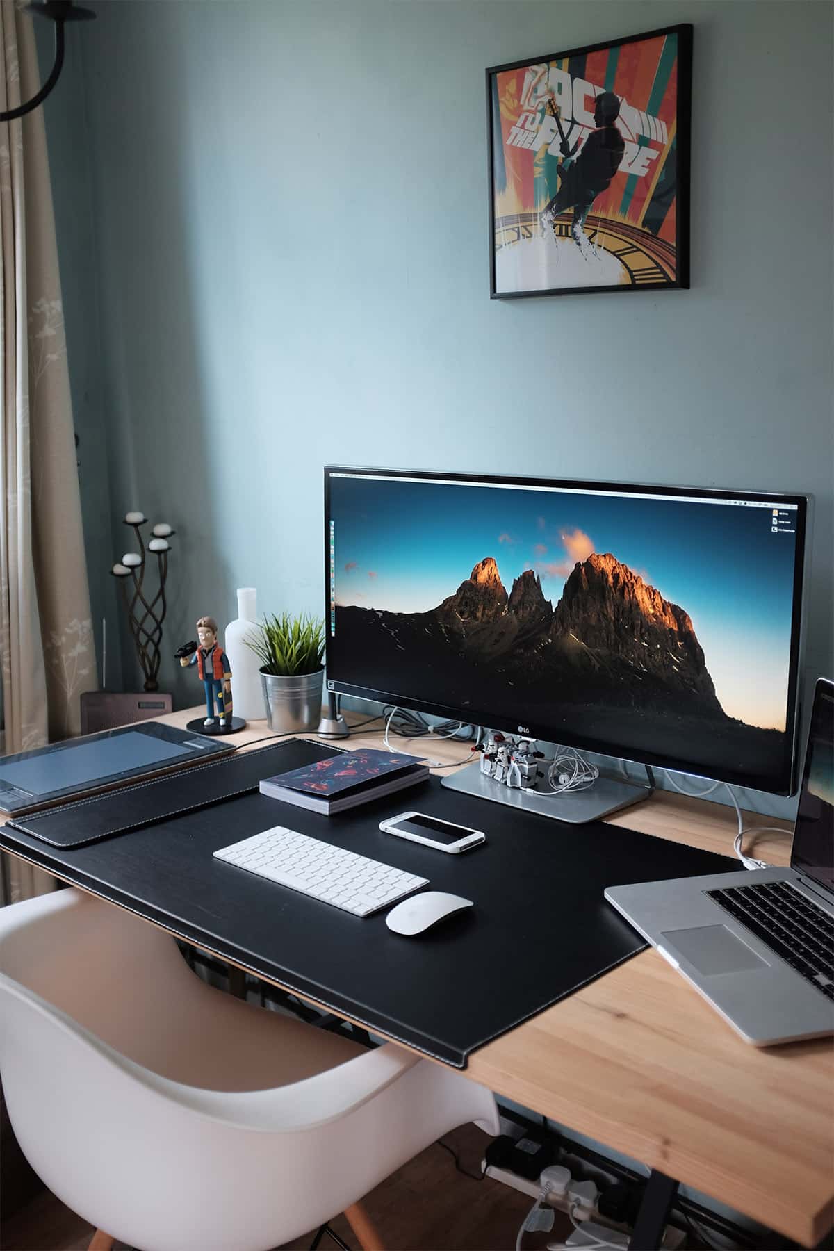 Home office desk with white keyboard in front of monitor and a white chair