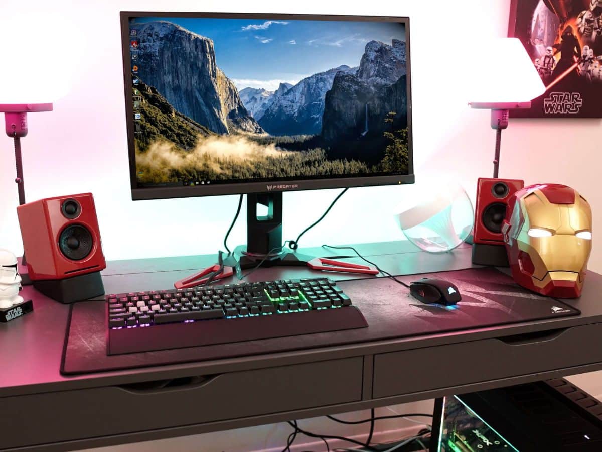 Home office desk with a computer and a iron man helmet in a corner