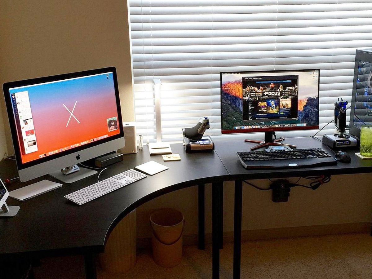 Black L-shaped desk with two PCs