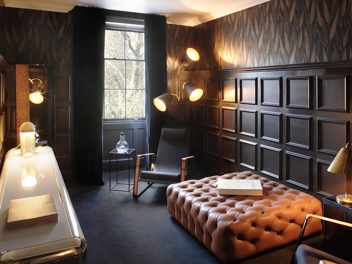 Masculine office with large leather slab couch and dark brown wood walls