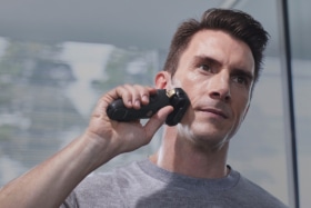 A man shaving with a Panasonic rechargeable shaver