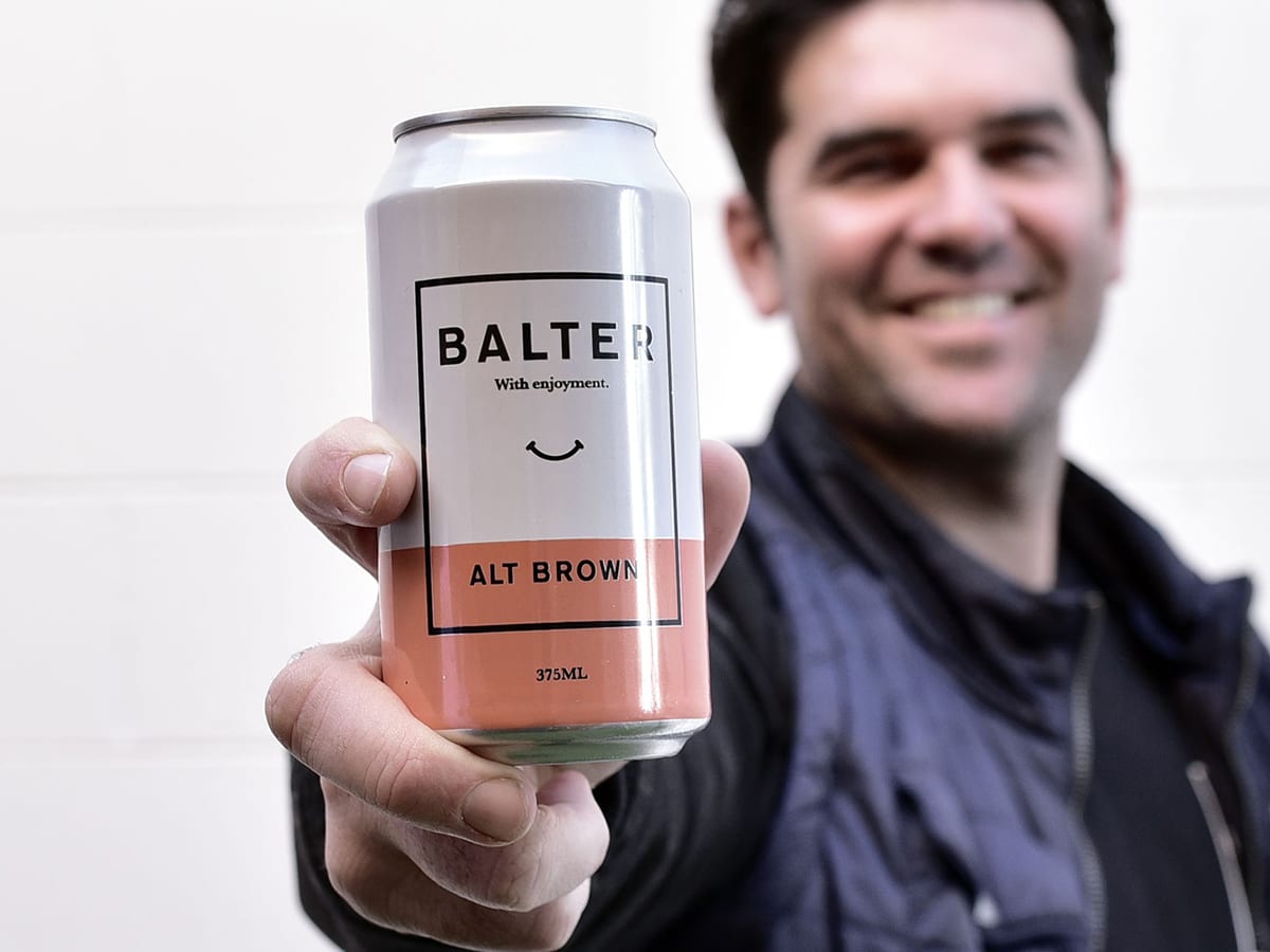 man holding balter alt brown beer