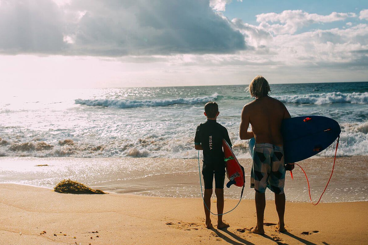 two surfers standing on the shelly beach