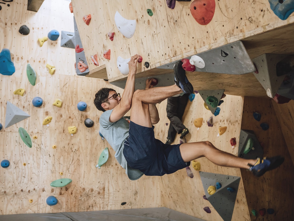 man climbing in boulder project rock climbing gym