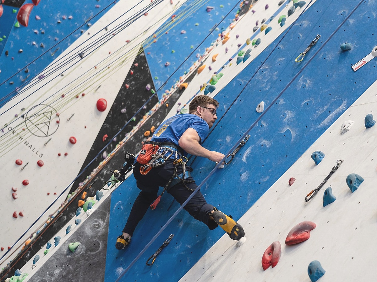 man climbing wall in north walls rock climbing gym