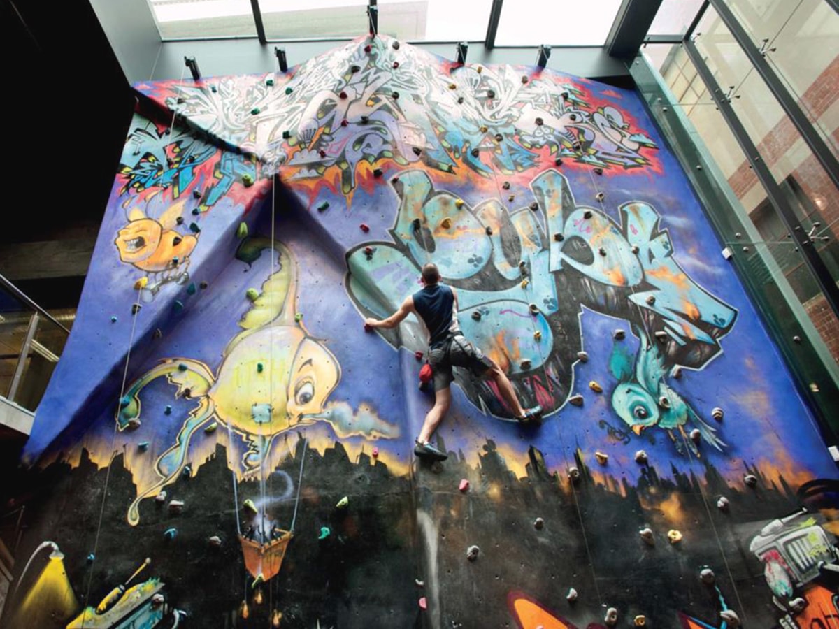 man climbing wall in virgin active rock climbing gym