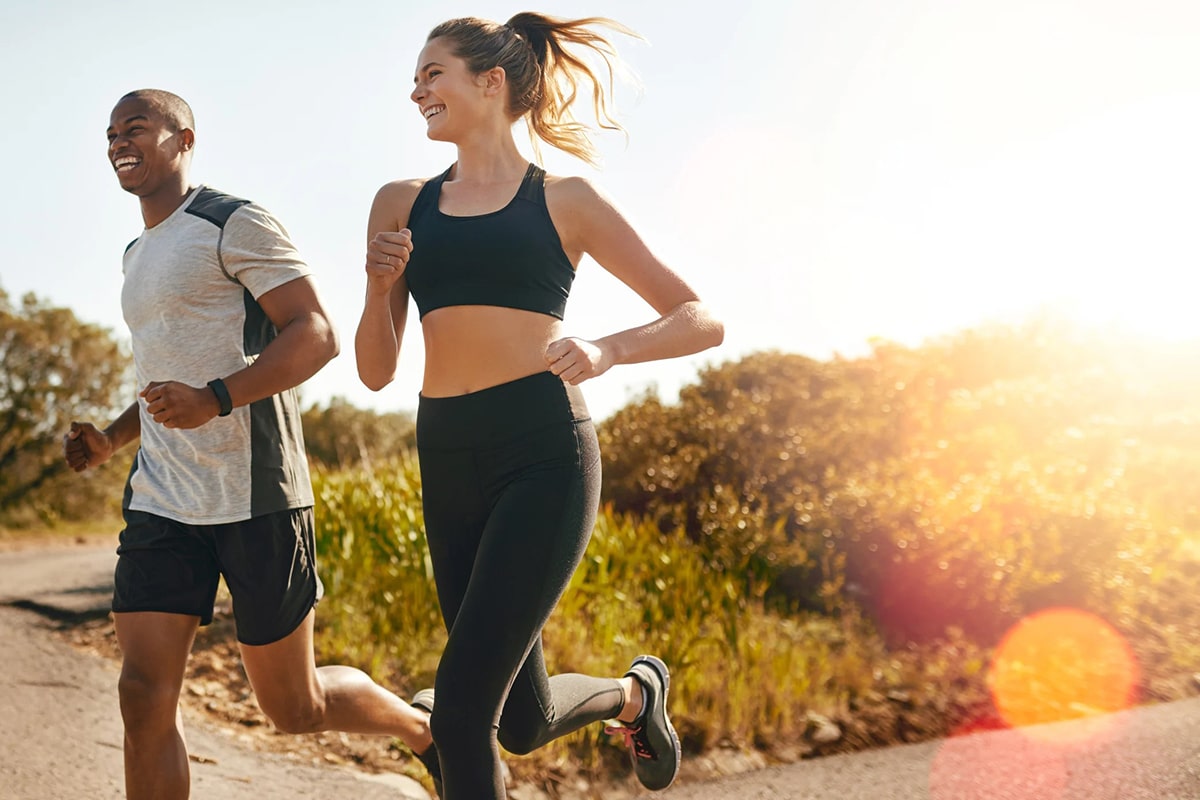 happy couple running on sunny day