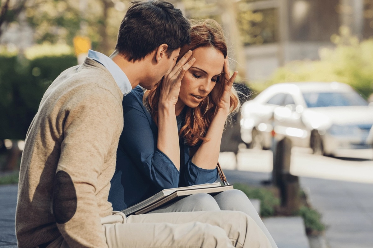 Stressed couple sitting on bench