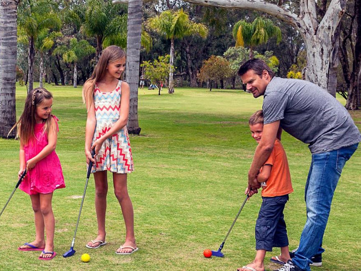 father with kids playing mini golf at oasis supa golf and adventure putt mini golf