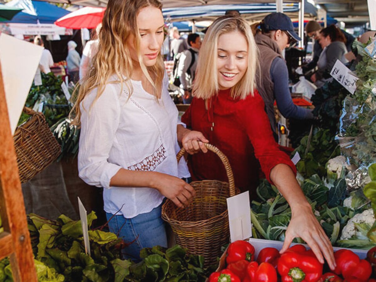young girls choosing vegetables at jan powers farmers markets