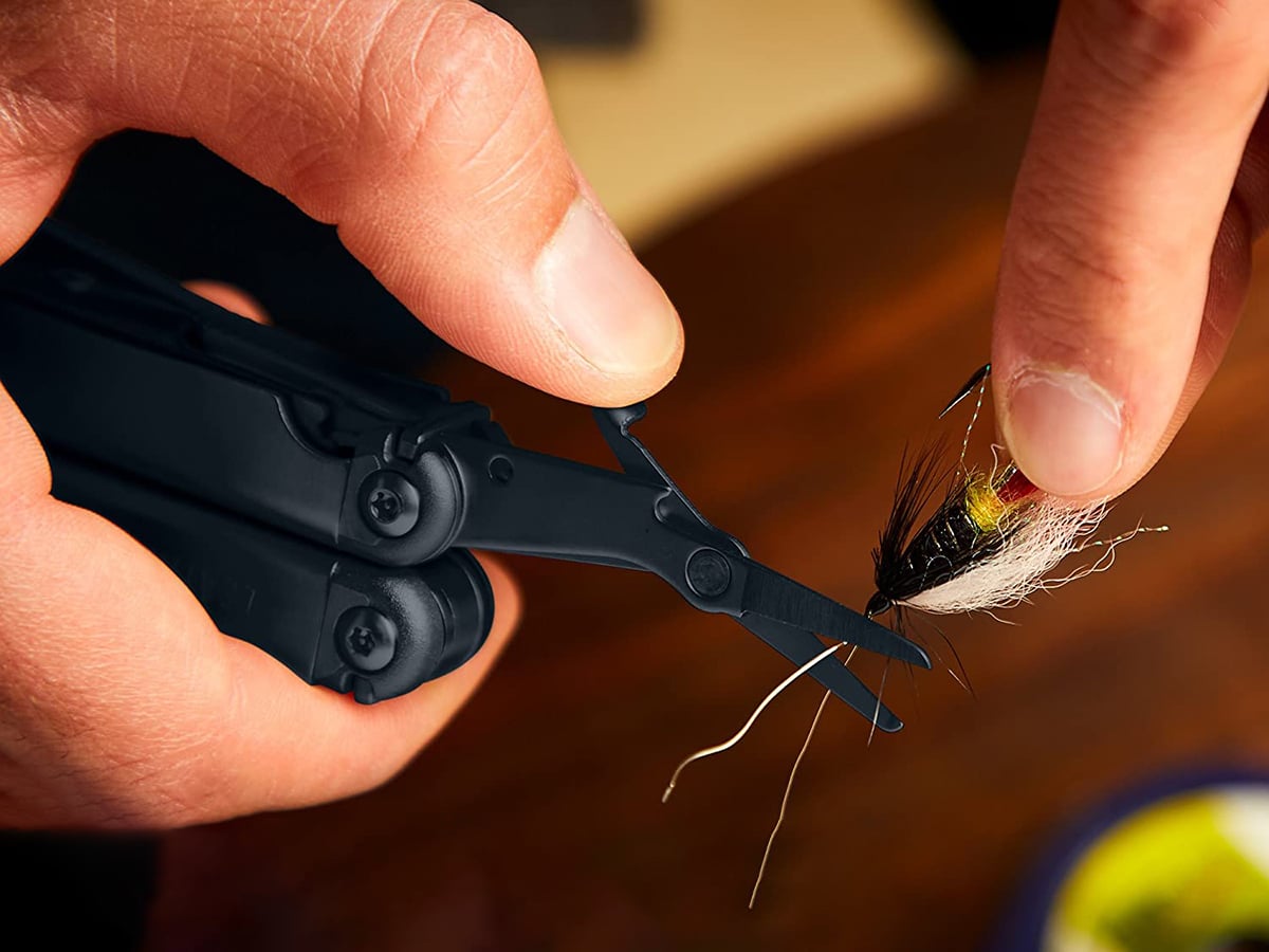 mans hand cutting with leatherman wave plus multitool