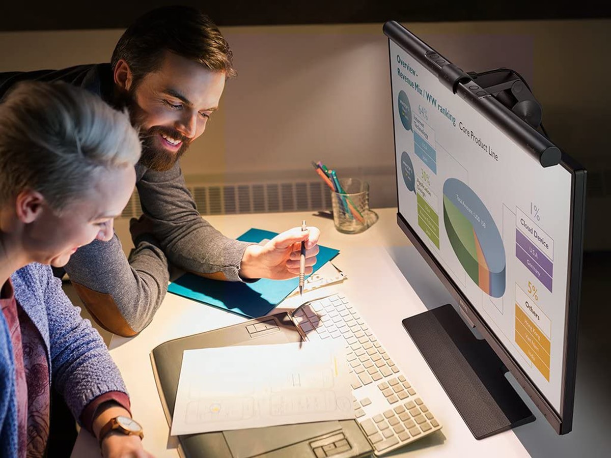 smiling man and woman sitting in front of computer with BenQ ScreenBar e-Reading LED Task Lamp