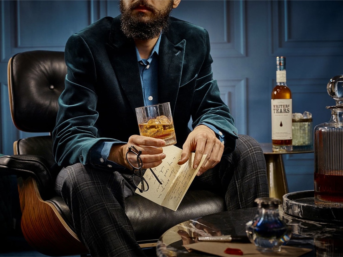 Man sitting on leather chair drinking whisky