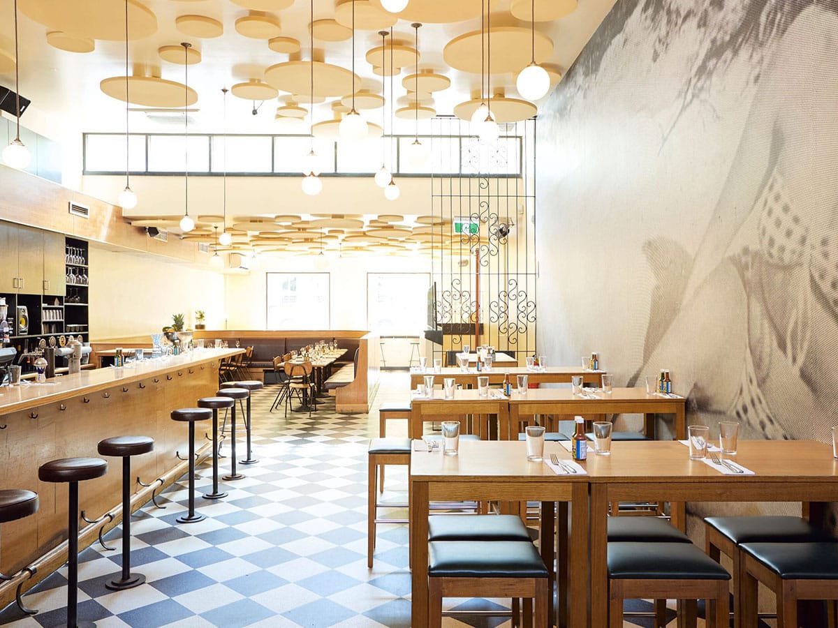 Interior of Mamasita restaurant with bright wood colour scheme showing tables, chairs and bar area