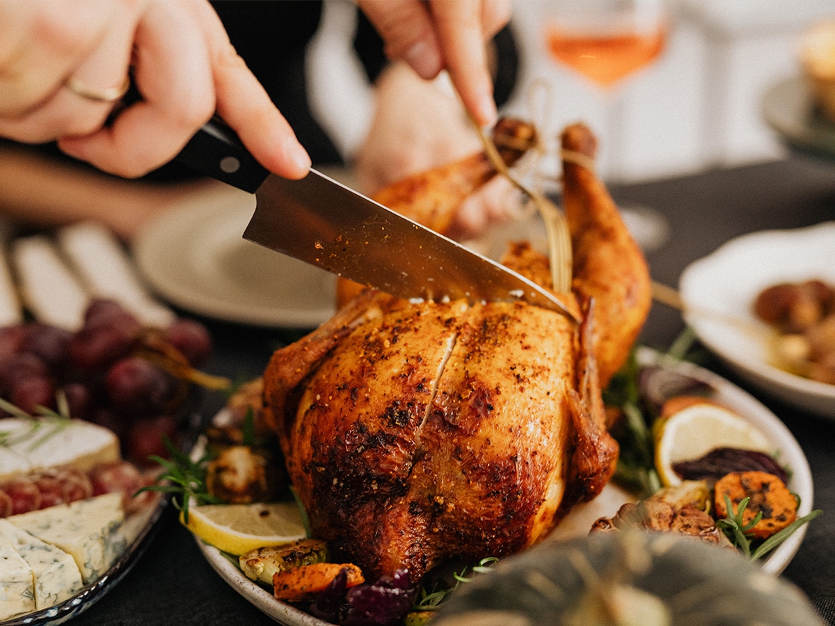 Cutting a roast chicken with a kitchen knife