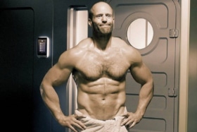 Shirtless Jason Statham with only a towel wrapped around his hips