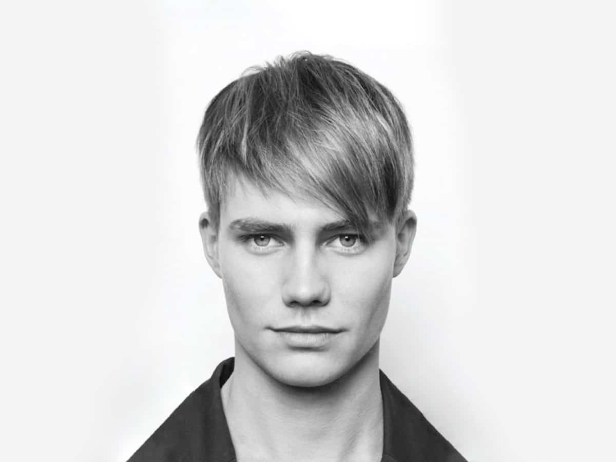 Greyscale image of male model with an angled fringe haircut