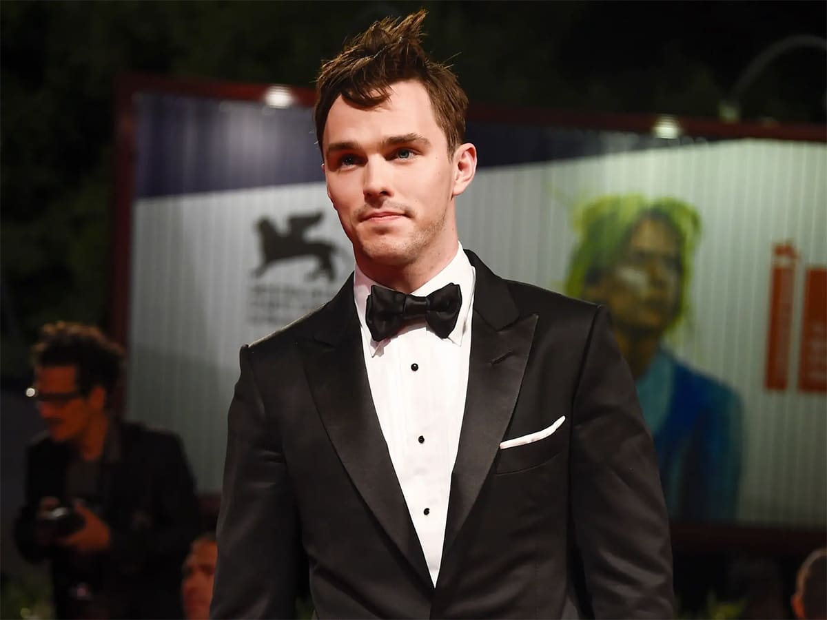 Nicholas Holt in black and white tuxedo with weird hairstyle