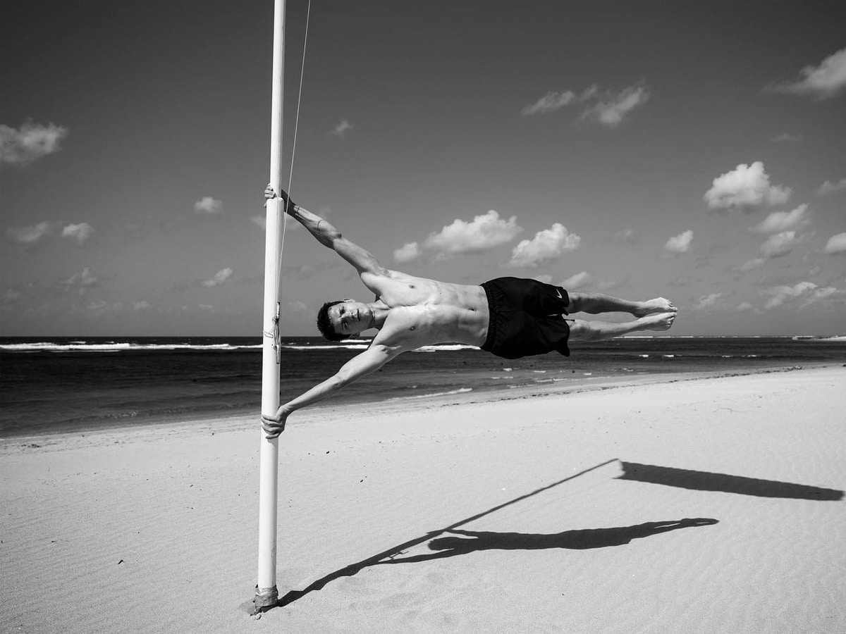 Tom Holland doing a horizontal handstand on a pillar