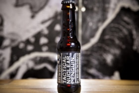 Close up of BrewDog Tactical Nuclear Penguin beer bottle set on a wooden bar