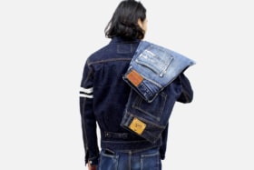 Back of a man with two jeans on his shuolder