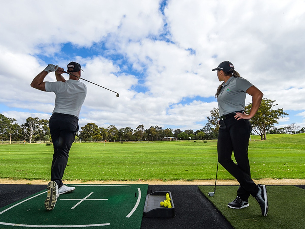 Two golfers playing on a sunny day at the Yarra Bend Golf Driving Range