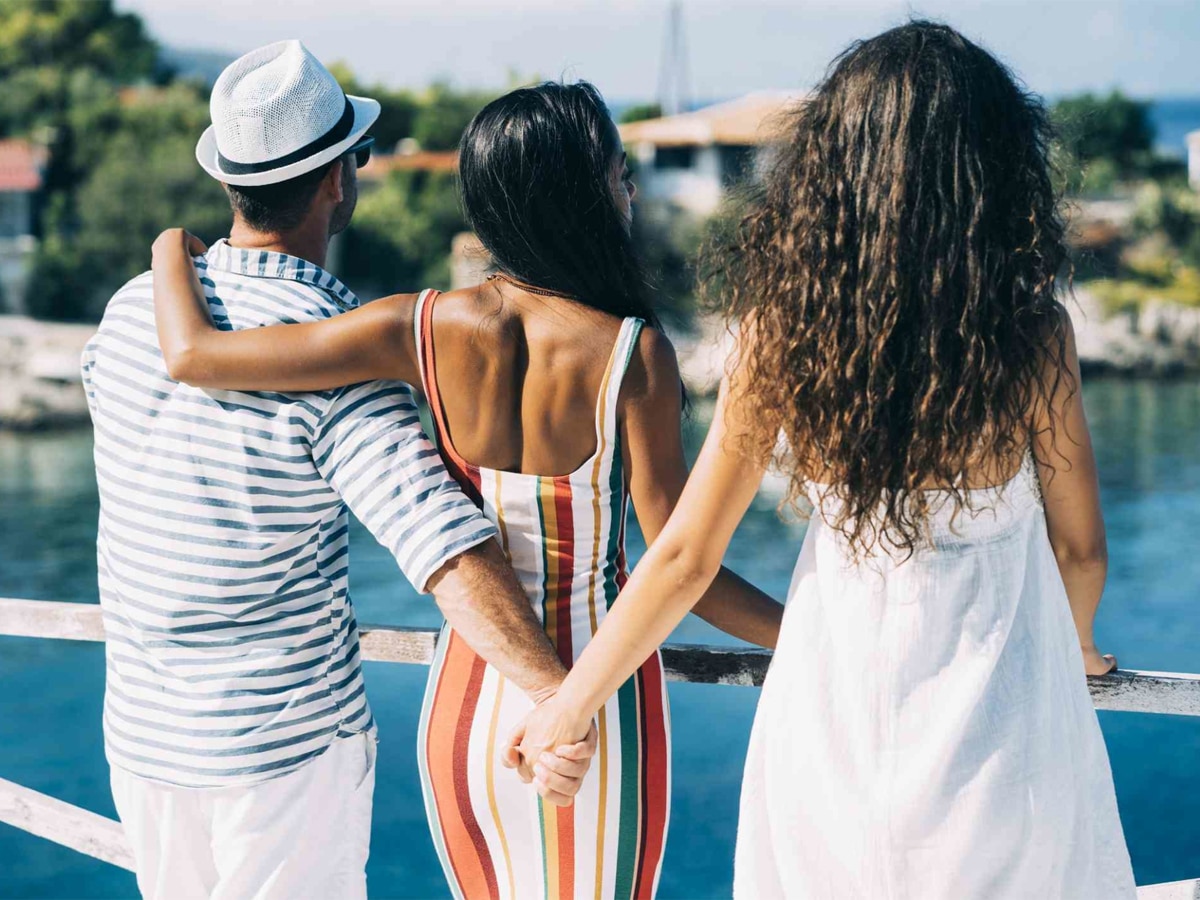 A man holding hand of a woman behind the back of standing with him