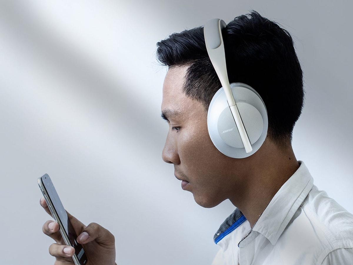 Close up of a man wearing headphones looking at his smartphone