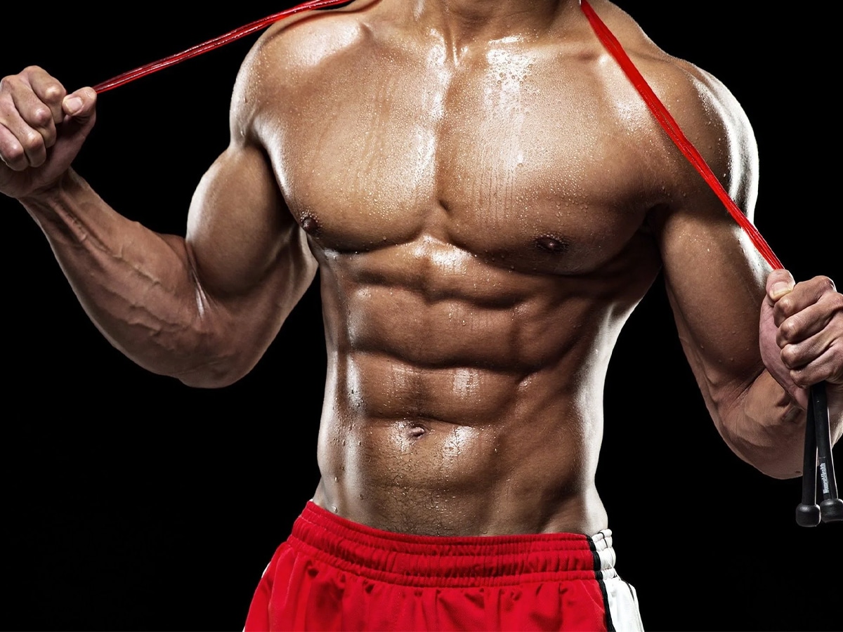 Shirtless man holding a jumping rope over his neck