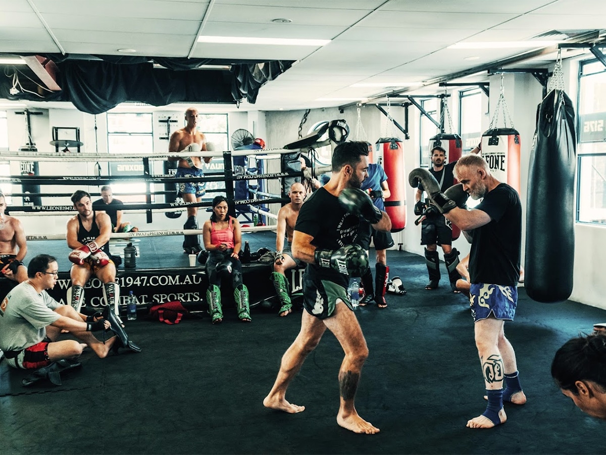 Two members sparring outside the ring while other members are watching at 8 Limbs martial arts gym