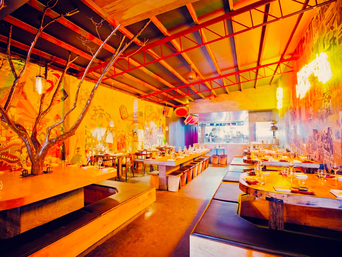 Interior of Etsu Izakaya restaurant showcasing vibrant painted walls adorned with LED signs and traditional style decor and furnishing