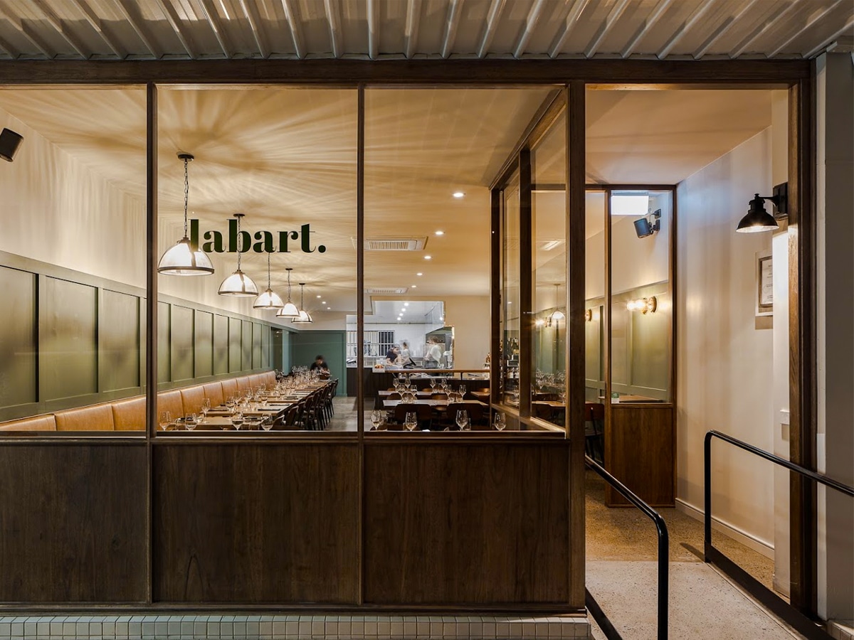 Front view of Restaurant Labart with expansive windows showing the wooden furnished interior