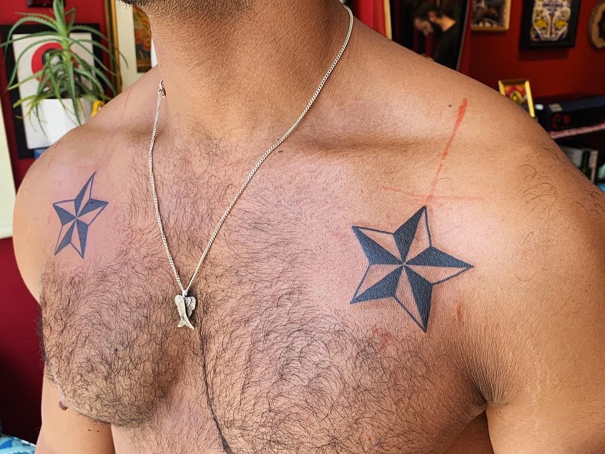 Chest tattoo of his son's footprint, name and the date