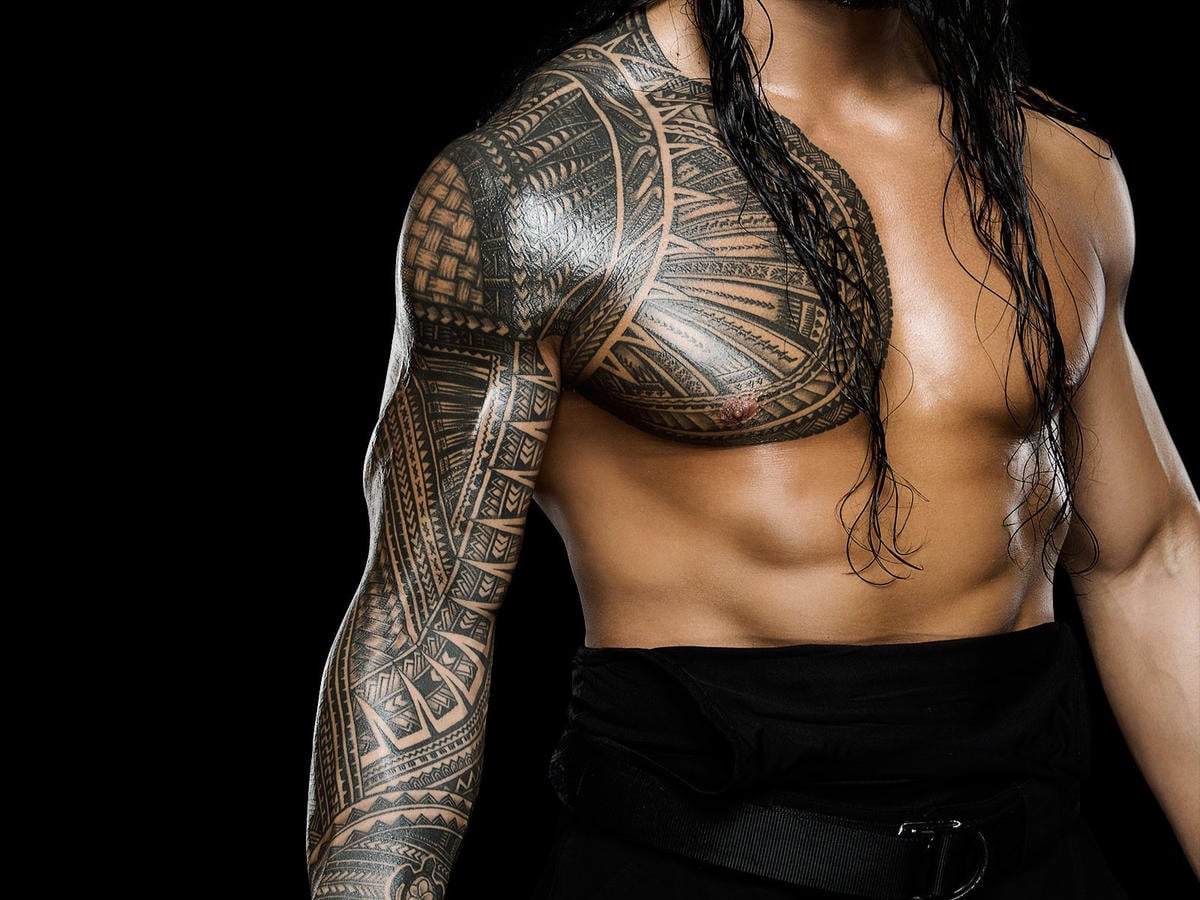 Half body shot of Roman Reigns showing Samoan tribal art black and gray tattoo sleeve on his right arm