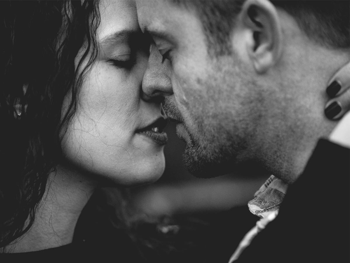 Grayscale photo of man and woman kissing each other