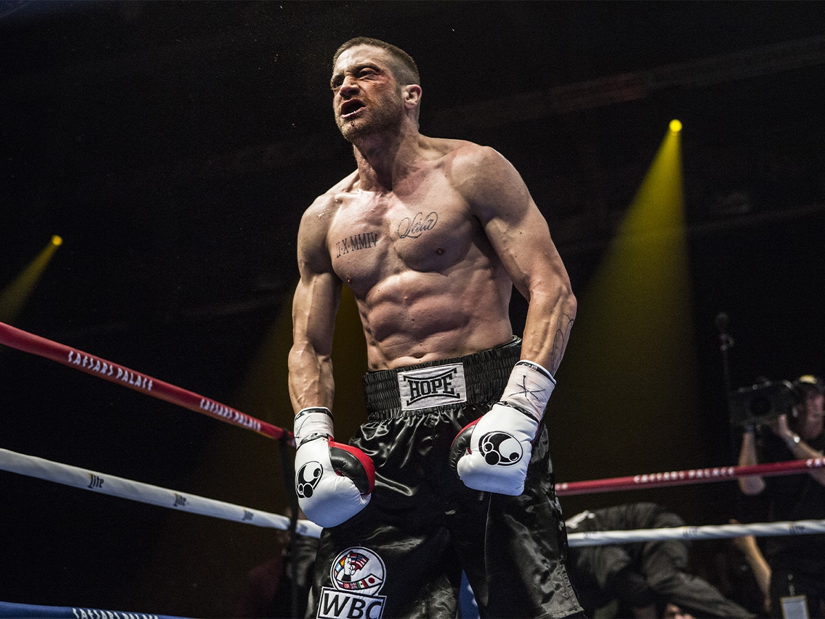 Jake Gyllenhaal wearing boxing shorts and gloves inside a boxing ring