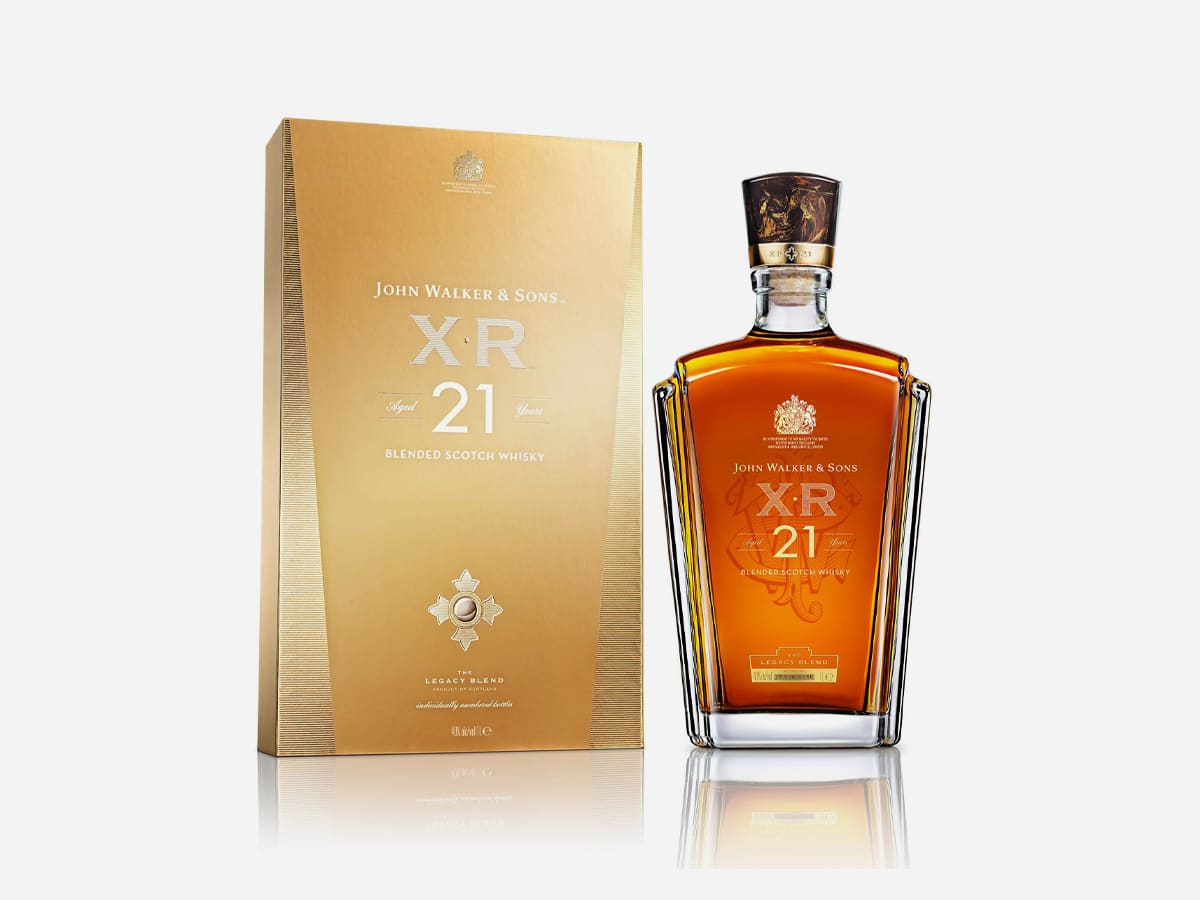 A bottle of premium whisky John Walker & Sons XR 21 and its box packaging displayed against a clean white background