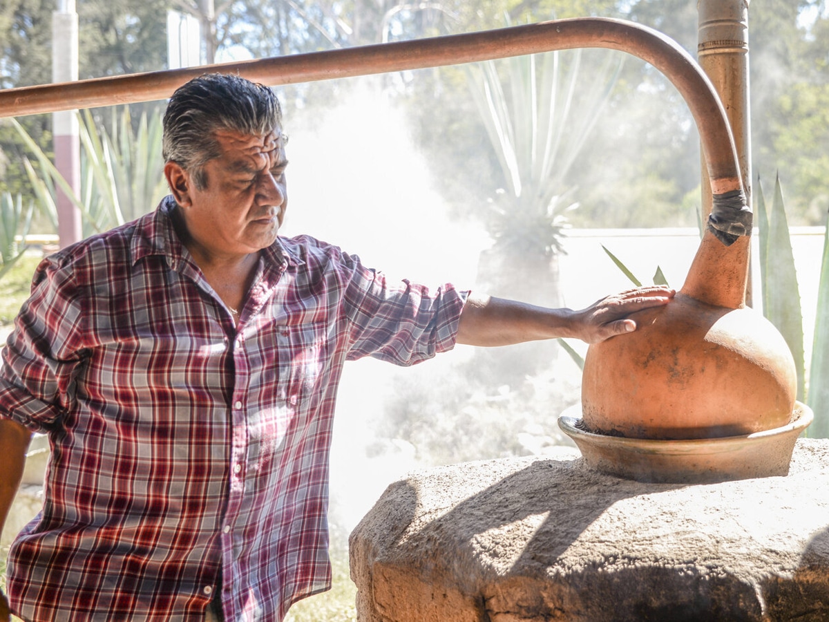 Man putting his hand on top of a clay pot still