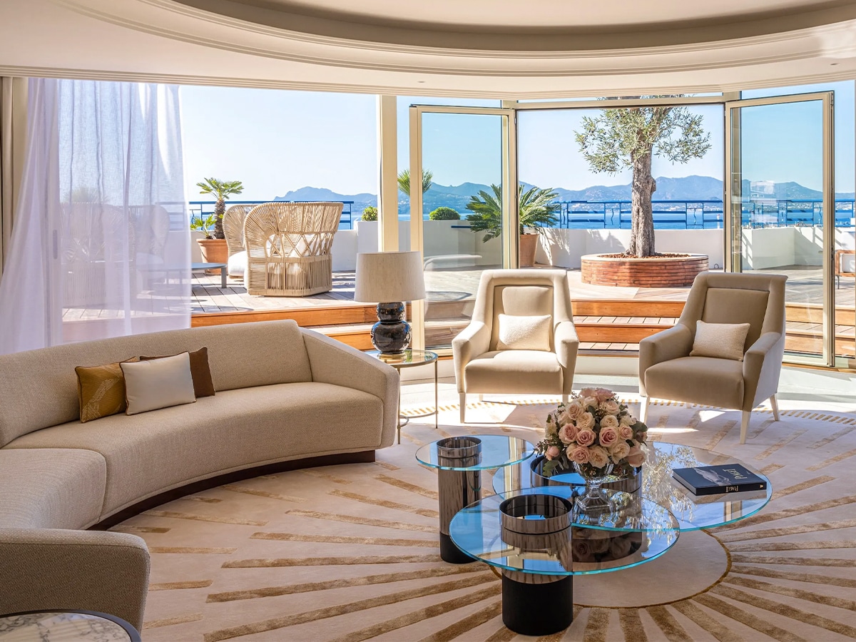 Interior of The Penthouse Suite Hotel Martinez lounge with expansive glass sliding doors and patio overlooking the scenic view of the sea