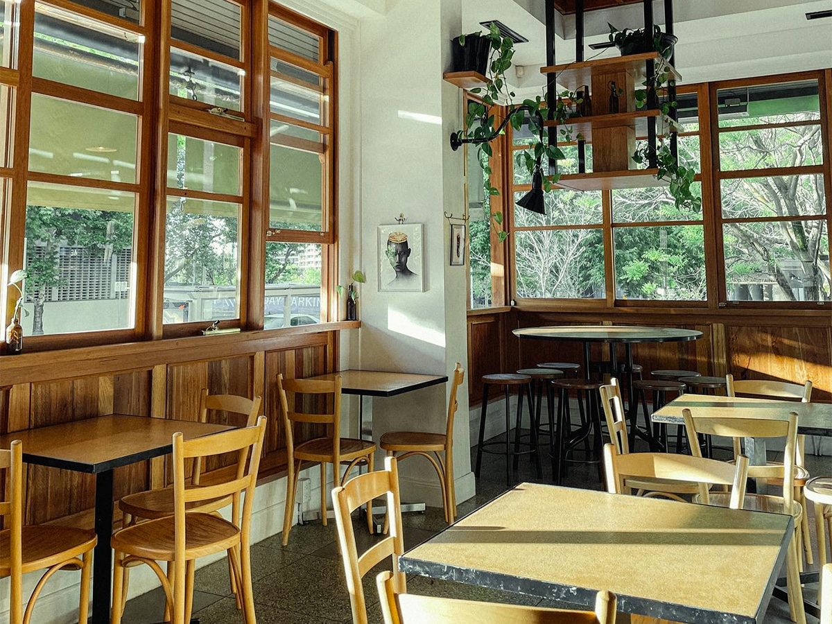 Interior of The Cupping Room cafe with wooden table and chairs and wide glass windows