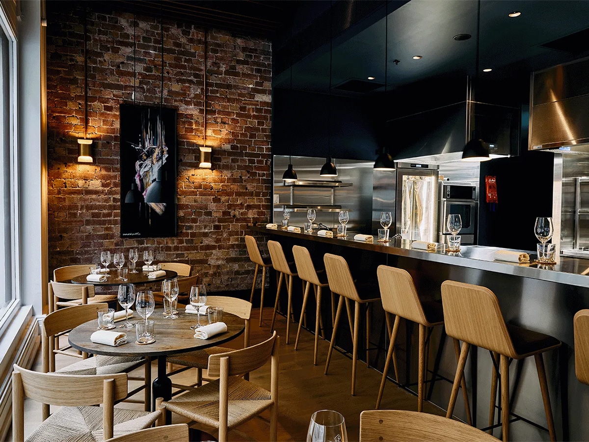 Interior of Freyja restaurant with wood and black colour scheme showing tables, chairs and bar area