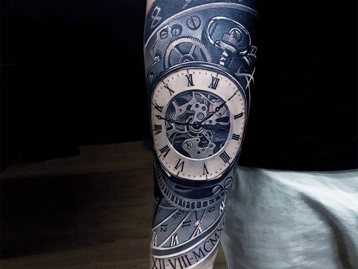 Close up of tattoo sleeve on man’s arm with clock design