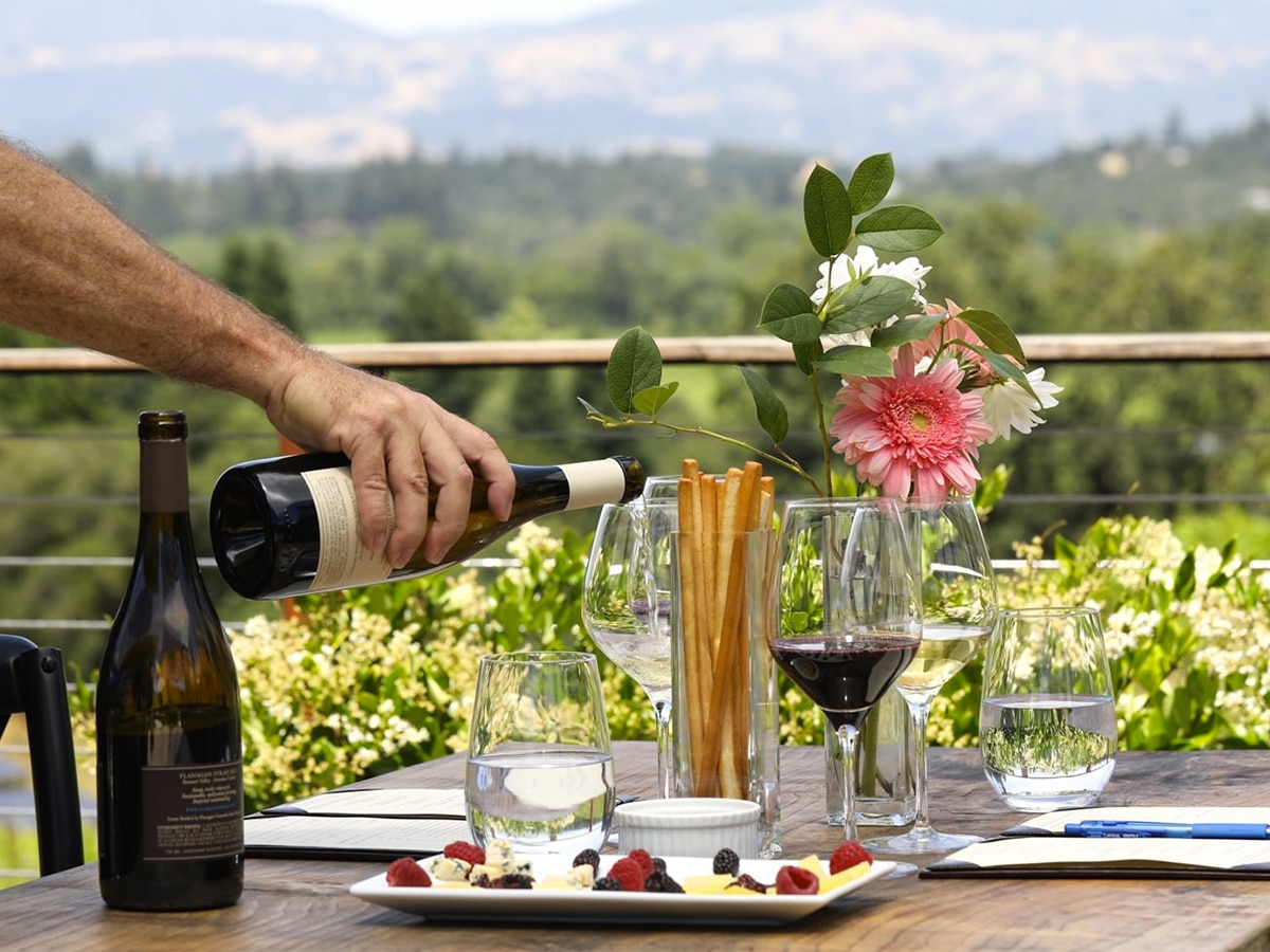 Table setup in focus with a hand pouring wine on a glass